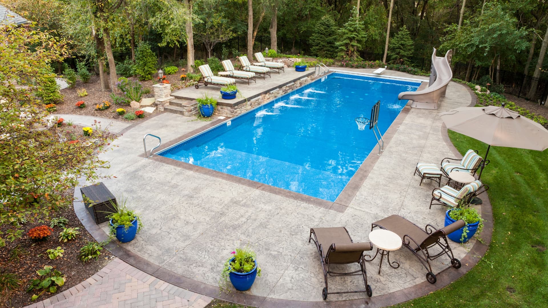 Premium backyard pool with slide and lounge chairs