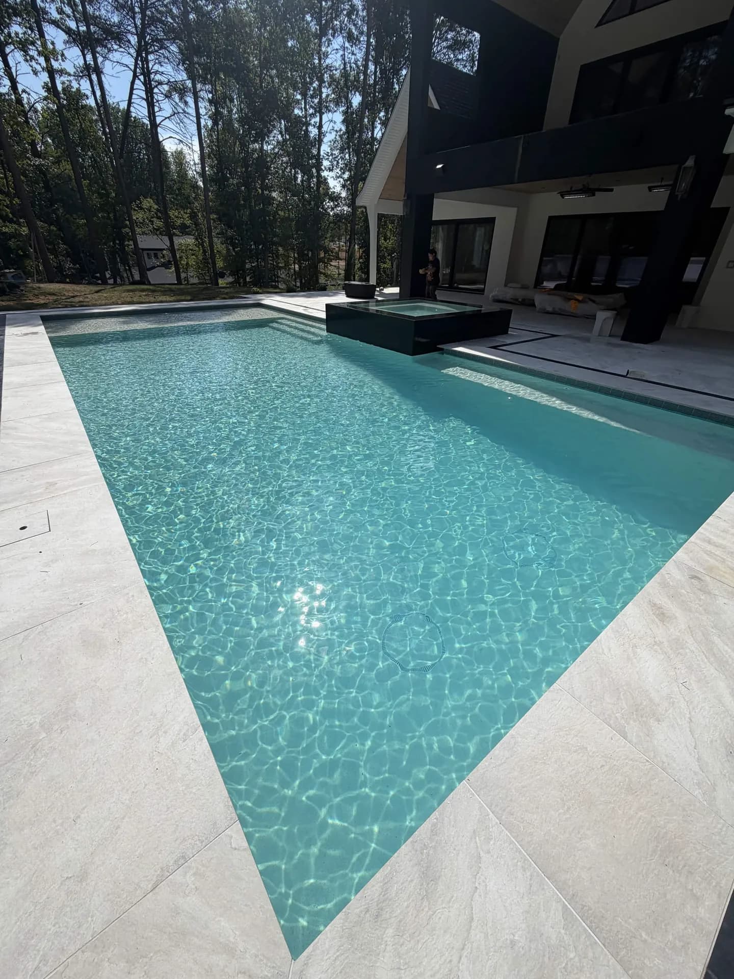 Modern backyard pool with a raised spa and clear water